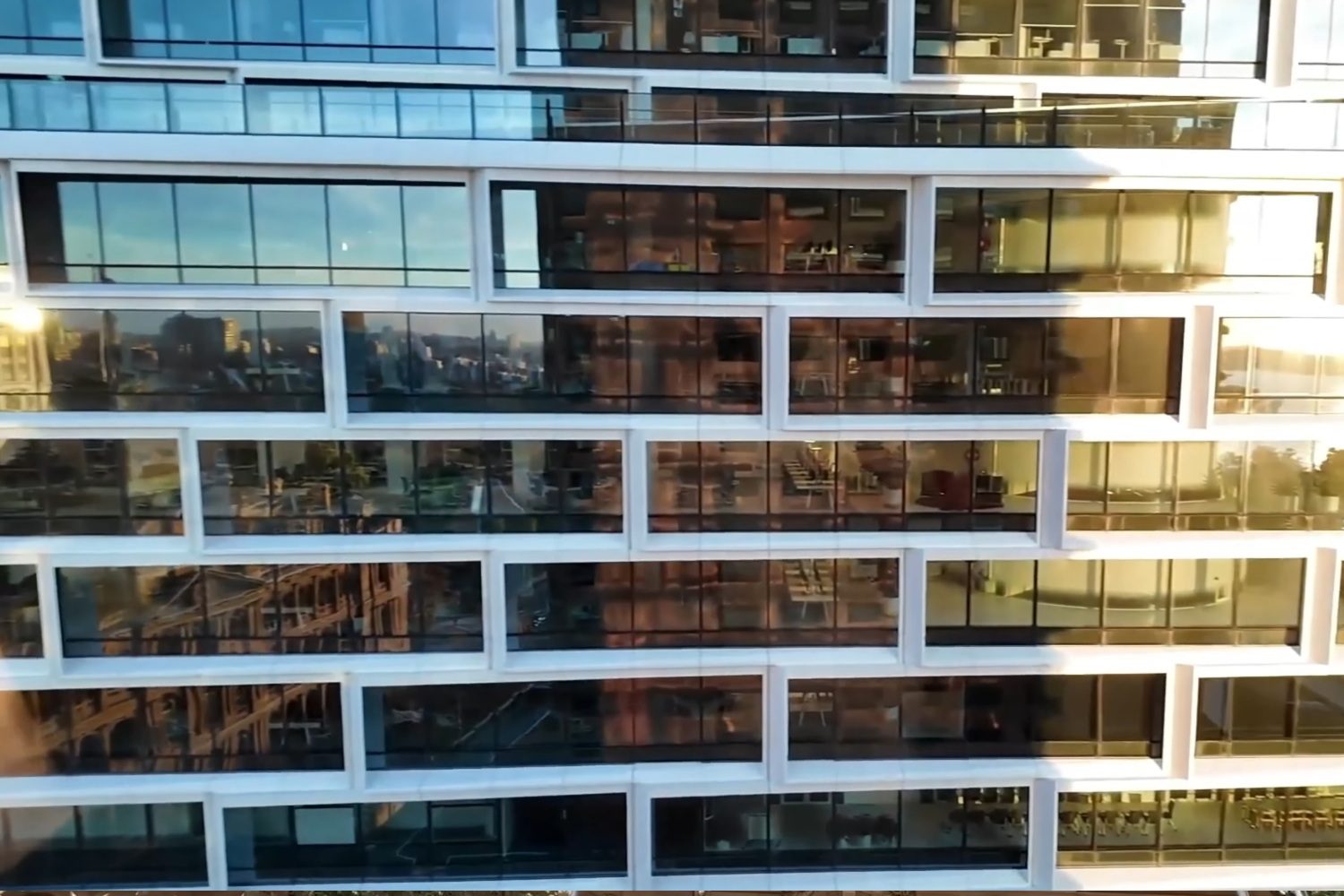 Façade vitrée d’un immeuble d’appartements du centre de Sydney éclairée par le soleil
